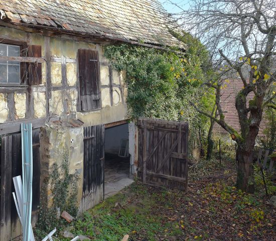 Hofseite der Scheune von 1655 mit Tor zum Garten; Fachwerk hauptsächlich mit Bruchsteinen ausgemauert, teilweise aber auch mit Astgeflecht und Lehm ausgefüllt.