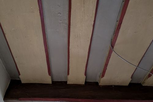 Die Balken-Bohlen-Decken aus dem 17. Jh haben sich flächig im gesamten Gebäude erhalten. In den meisten Räumen zur Zeit der Begehung 2025 noch unter jüngeren Deckenkonstruktionen verborgen. Wo sie frei lagen, waren sie mit Farbanstrichen versehen.